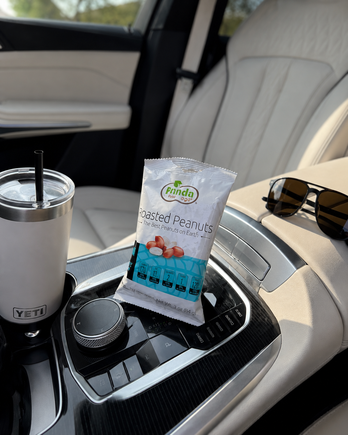 Pinda Lightly Salted Roasted Peanuts in a car cupholder next to a YETI tumbler
